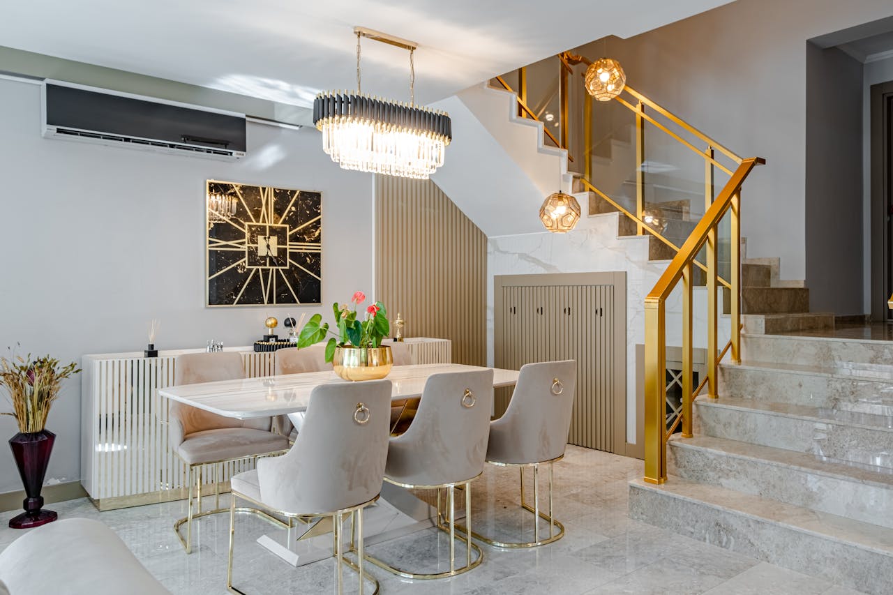 why-choose-us Modern dining room with marble table, gold accents, and stylish lighting.